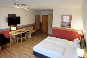 um quarto de hotel com uma cama e uma pequena mesa em Romantica Hotel Blauer Hecht em Dinkelsbühl