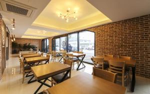 a restaurant with tables and chairs and a brick wall at Busan Station BUSAN VIEW HOTEL in Busan
