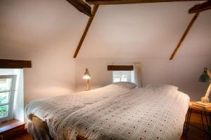 um quarto com uma cama com uma colcha branca em Mergelhuisje anno 1799 em Valkenburg