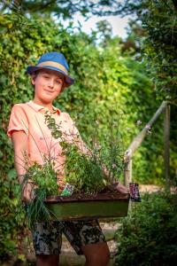 un joven sosteniendo un plantador con una planta en Mergelhuisje anno 1799 en Valkenburg