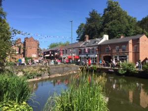 un groupe de personnes assises sur un pont sur une rivière dans l'établissement Lymm Boutique Rooms, à Lymm