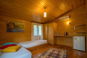 1 dormitorio con 1 cama en una habitación de madera en Baraka House, en Cıralı