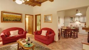 una sala de estar con 2 sillas rojas y una mesa. en Cappannelle Country House Tuscany, en Castiglion Fibocchi