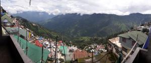 Vistas a una ciudad con montañas en el fondo en White Tara home stay, en Darjeeling