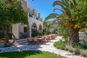 Hotel Naxos Beach في ناكسوس تشورا: فناء فيه طاولات وكراسي امام مبنى