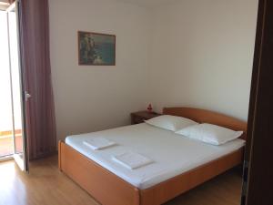 a bedroom with a bed with two white pillows at Apartment Kastel in Podgora