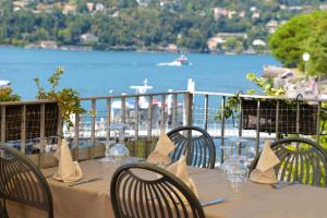 a table with chairs and a view of the water at Hotel Marco's in Como