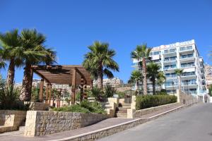 a building with palm trees in front of a street at Arenales Beach in Arenales del Sol