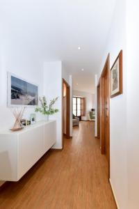 - un salon avec des murs blancs et du parquet dans l'établissement Lasi house, à Serra San Bruno