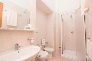 a white bathroom with a toilet and a sink at Hotel Fontana in Amalfi