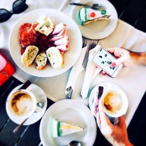 uma mesa coberta com pratos de comida e chávenas de café em Pensiunea SanMartin em Sânmartin