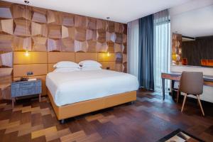 Habitación de hotel con cama, escritorio y escritorio. en Emerald Hotel, en Pristina
