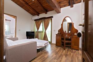 スンマルティンにあるPensiunea SanMartinのベッドと机と鏡のある寝室