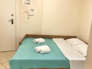 łóżko szpitalne z dwoma składanymi ręcznikami w obiekcie Seaview 2nd flr. apt. next to the beach, wifi,a/c,p/c media. w mieście Anavissos
