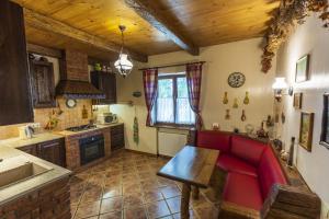 a living room with a red couch in a kitchen at Гостинний двір на хуторі Хрещатик in Khreshchatik