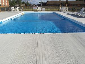 a swimming pool with blue water and some chairs at Niagara Holiday Apartment in Niagara Falls