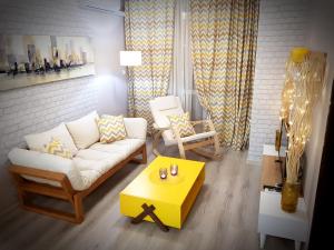 uma sala de estar com um sofá branco e uma mesa amarela em Best Guest Apartments em Plovdiv