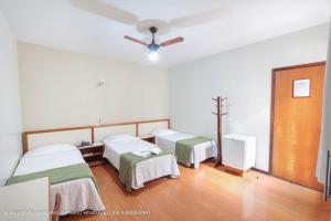 a hospital room with two beds and a ceiling fan at Hotel Princeton in Piracicaba