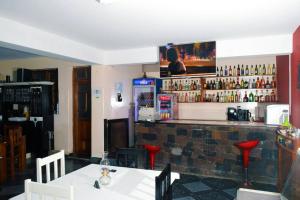 ein Restaurant mit einer Bar mit einem TV an der Wand in der Unterkunft Hotel Miramar Fogo Brava in São Filipe