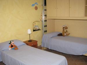sypialnia z dwoma łóżkami z pluszowymi zwierzętami siedzącymi na nich w obiekcie La Casa sul Fiume Aquila w mieście Finale Ligure