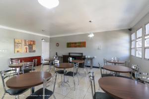 a dining room with wooden tables and chairs at Hotel Princeton in Piracicaba
