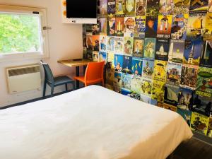 a bedroom with a bed and a wall covered in posters at hotelF1 Genève Aéroport Ferney in Ferney-Voltaire