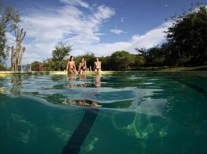 a group of people standing in a pool of water at Complejo Megevand in Río Ceballos