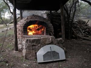 a stone oven with a fire inside of it at Complejo Megevand in Río Ceballos