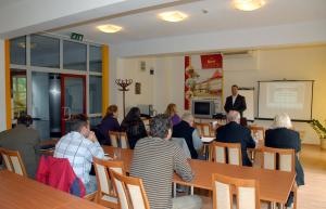 a group of people sitting at tables in a room at Sport Hotel in Debrecen