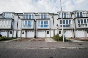 a large white building with white doors and windows at Woodlands Luxury 4 Bedroom Townhouse Cults in Aberdeen