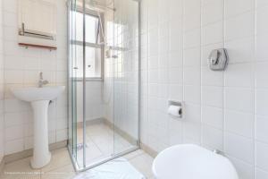 a bathroom with a shower and a toilet and a sink at Hotel Princeton in Piracicaba