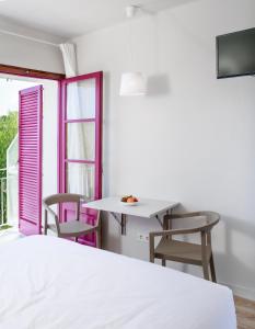 um quarto com uma cama, uma mesa e cadeiras em Bellsol Rooms em Pineda de Mar