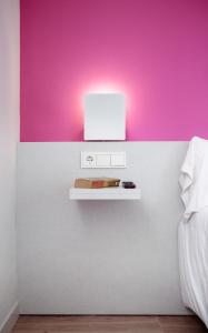 a white shelf on a wall with a pink wall at Bellsol Rooms in Pineda de Mar