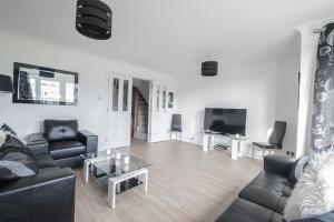 sala de estar con sofá y TV en Woodlands Luxury 4 Bedroom Townhouse Cults en Aberdeen