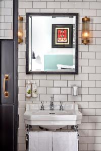 a white bathroom with a sink and a mirror at The Coach in London