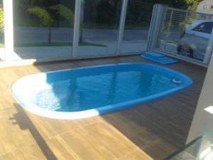 a large swimming pool in a house with a porch at Ap Praia De Palmas in Governador Celso Ramos