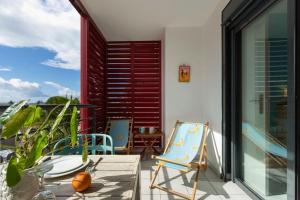 a patio with two chairs and a table on a balcony at Ti Macoua Studio bord de mer in Saint-Pierre