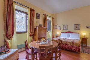 una camera d'albergo con un letto e un tavolo e un letto e un tavolo di La Casa Del Garbo - Luxury Rooms & Suite a Firenze