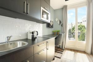 eine Küche mit einem Waschbecken und einem Fenster in der Unterkunft Paris Eiffel by YAYS in Paris