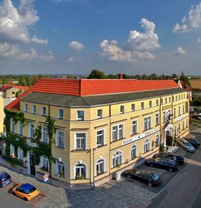 um grande edifício amarelo com um telhado vermelho em Hotel Schwarzes Ross em Siebenlehn