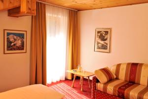 ein Hotelzimmer mit einem Sofa und einem Fenster in der Unterkunft Hotel Sport Robert in Sulden