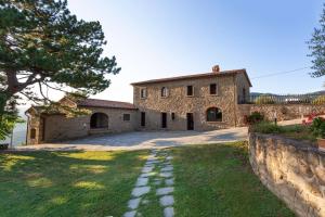 an external view of a stone house with a yard at Agriturismo Le Celle in Cortona