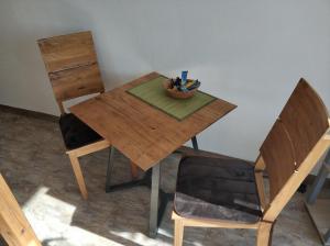 a wooden table with a bowl of pens and a chair at Lovely Studio in Cannstatt in Stuttgart