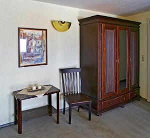 Zimmer mit einem Tisch, einem Stuhl und einem Schrank in der Unterkunft Hotel Schwarzes Ross in Siebenlehn