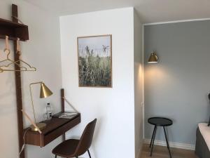 a bedroom with a bed and a desk and a chair at Hotel Løkken Strand in Løkken