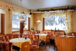 un restaurant avec deux tables et des chaises ainsi qu'une fenêtre dans l'établissement Hotel Sport Robert, à Sulden