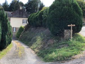 a road in front of a house with a street sign at Le Tywizou in Mellé