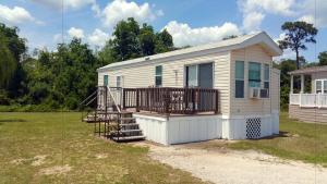 a tiny house with a porch and a deck at Orlando RV Resort in Orlando