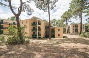 an apartment building with trees in front of it at Residence Les Grands Pins - maeva Home in Carcans