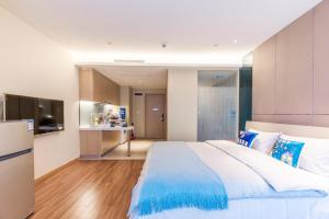 a bedroom with a large bed and a kitchen at Chengdu Hi - Tech·Global Center Locals Apartment 00139620 in Chengdu